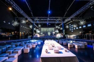 Sala ricevimenti con un tavolo centrale lungo bianco, sedute ai lati e luci soffuse