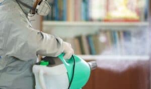 immagine ravvicinata di operatore che sanifica un ambiente